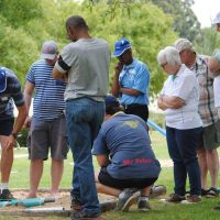 Players and spectators around jukskei sandpit